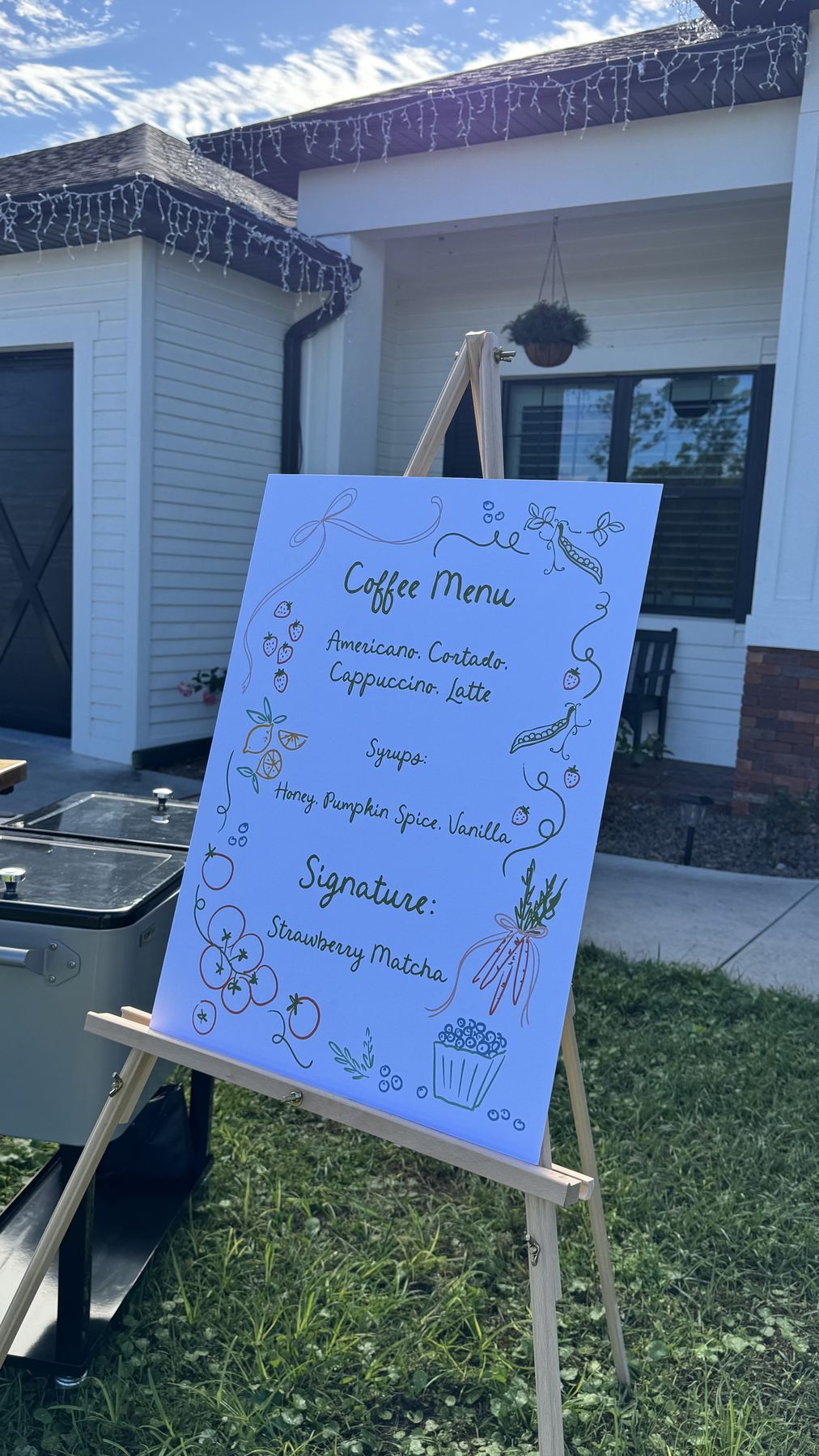 Hand-drawn coffee menu sign on an easel